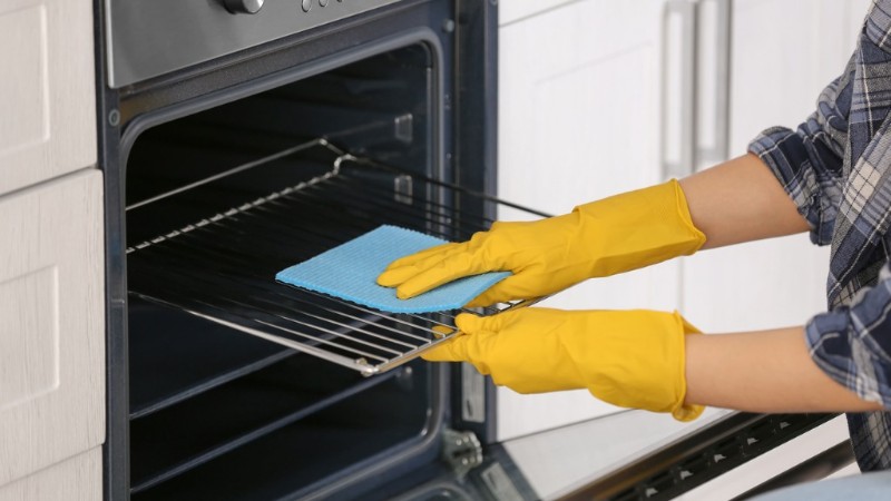 woman-cleaning-oven-in-kitchen-closeup-picture-id942141666
